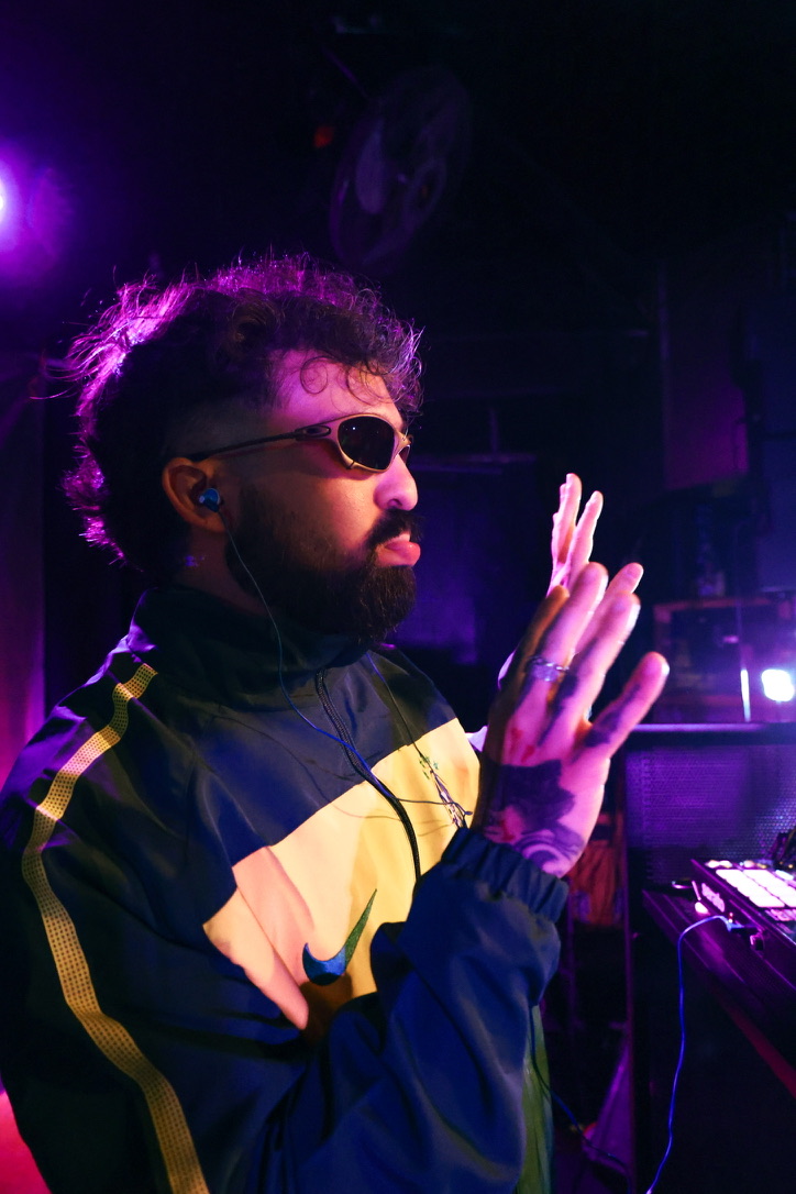 JG Garçon performing as a DJ under purple stage lighting